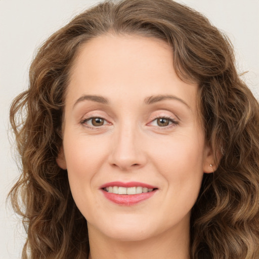 Joyful white young-adult female with long  brown hair and green eyes