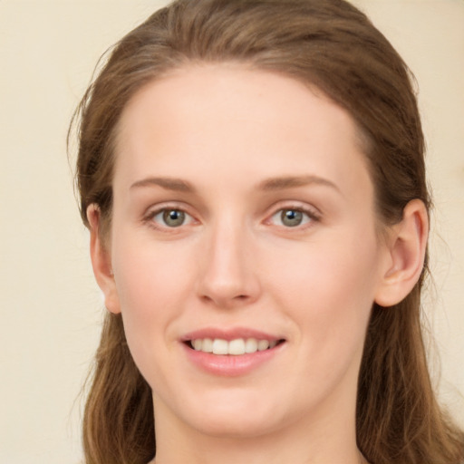 Joyful white young-adult female with long  brown hair and green eyes