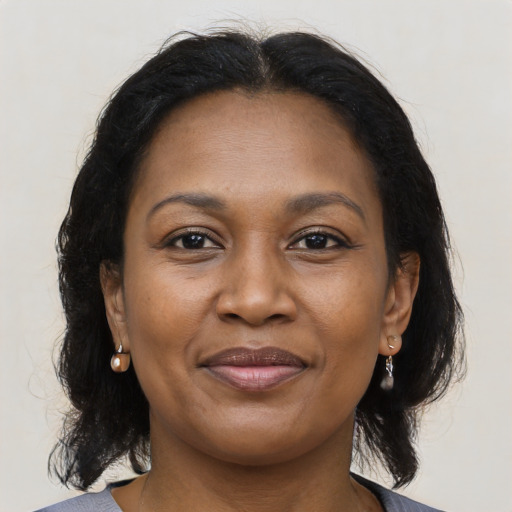 Joyful black adult female with medium  brown hair and brown eyes