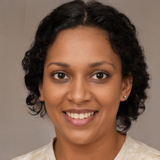 Joyful black young-adult female with medium  brown hair and brown eyes
