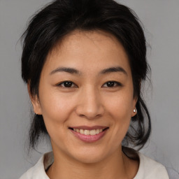 Joyful asian young-adult female with medium  brown hair and brown eyes