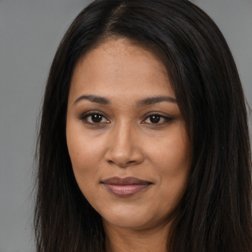 Joyful latino young-adult female with long  brown hair and brown eyes