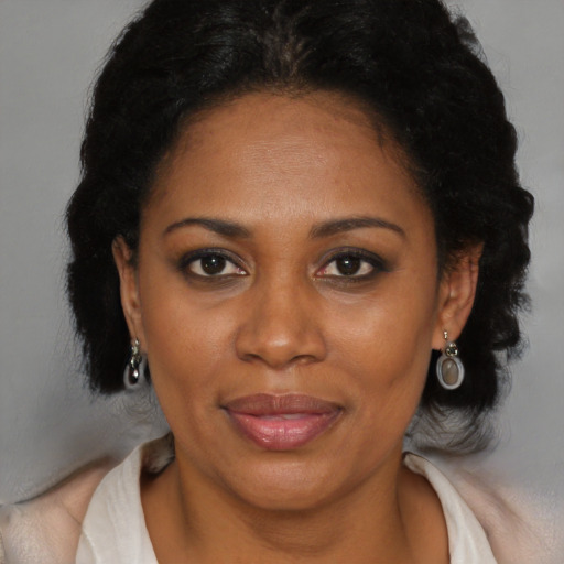 Joyful black adult female with medium  brown hair and brown eyes