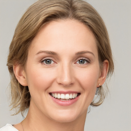 Joyful white young-adult female with medium  brown hair and green eyes