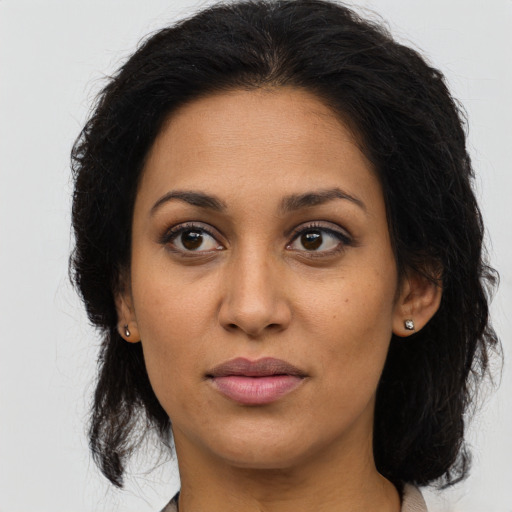 Joyful latino young-adult female with long  brown hair and brown eyes