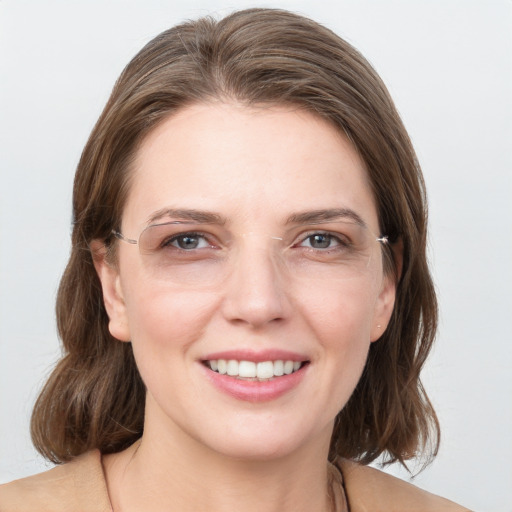 Joyful white young-adult female with medium  brown hair and grey eyes