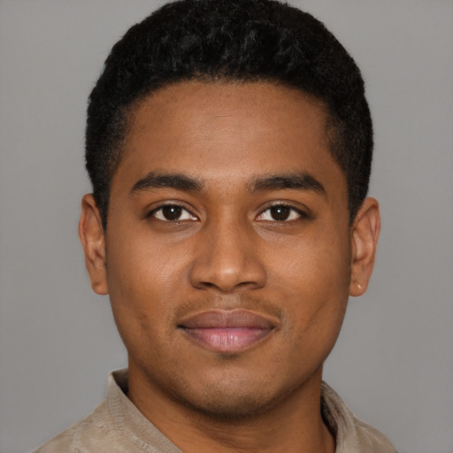 Joyful black young-adult male with short  black hair and brown eyes