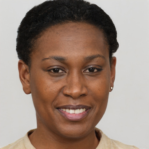 Joyful black young-adult female with short  brown hair and brown eyes