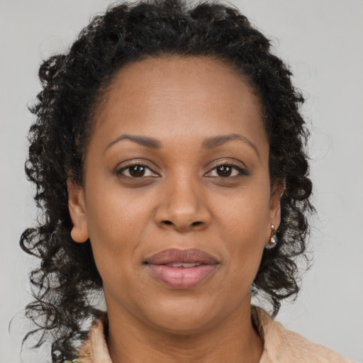 Joyful black adult female with long  brown hair and brown eyes