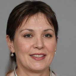 Joyful white adult female with medium  brown hair and grey eyes