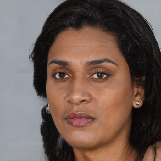 Joyful black young-adult female with long  black hair and brown eyes