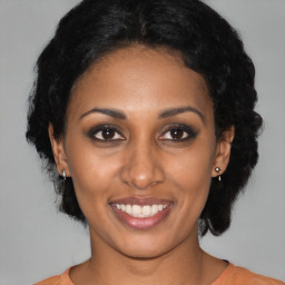 Joyful black young-adult female with medium  black hair and brown eyes