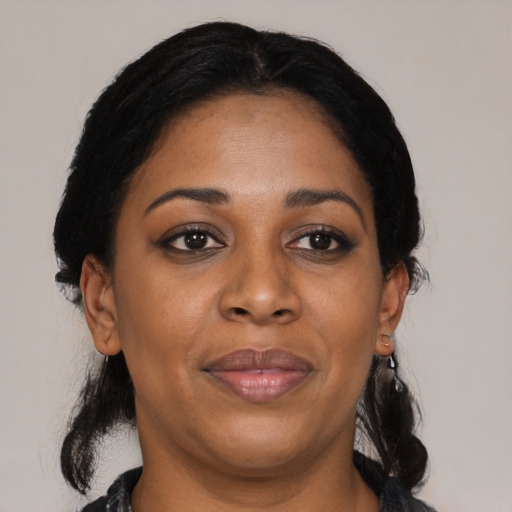 Joyful black adult female with medium  black hair and brown eyes