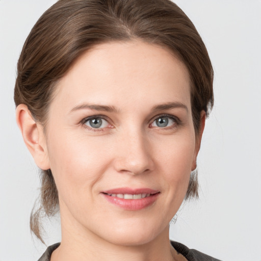 Joyful white young-adult female with medium  brown hair and grey eyes