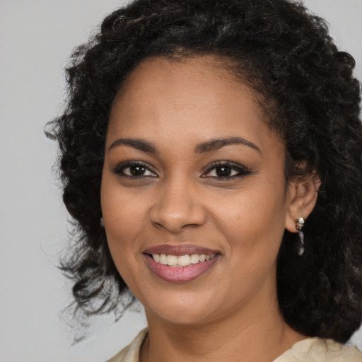 Joyful black young-adult female with long  brown hair and brown eyes