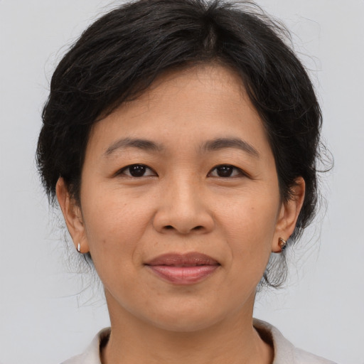 Joyful asian adult female with medium  brown hair and brown eyes