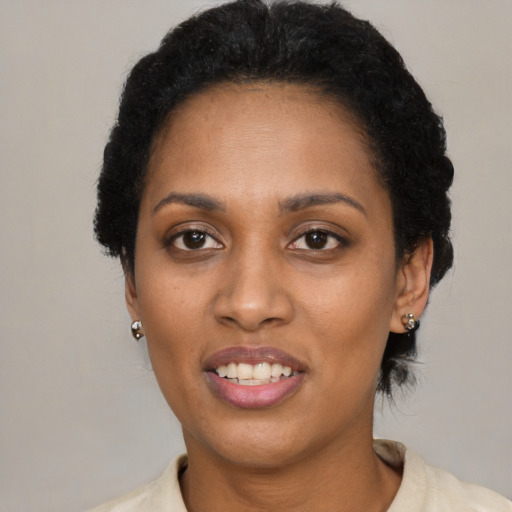 Joyful black young-adult female with short  black hair and brown eyes