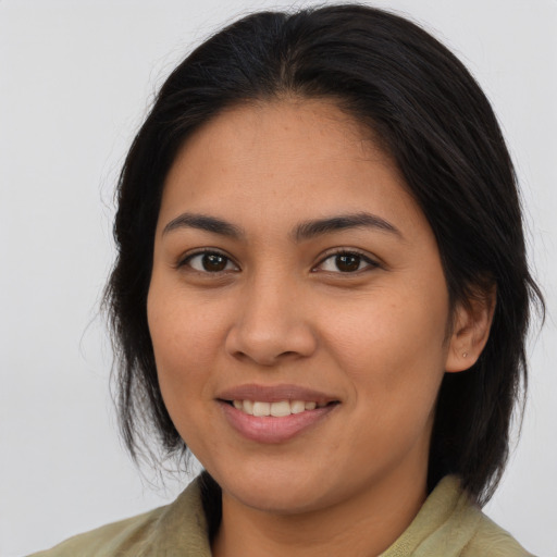 Joyful latino young-adult female with medium  brown hair and brown eyes