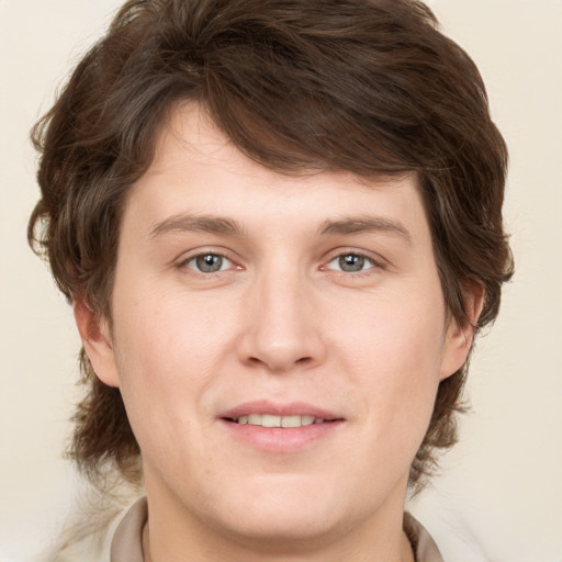 Joyful white young-adult male with medium  brown hair and grey eyes