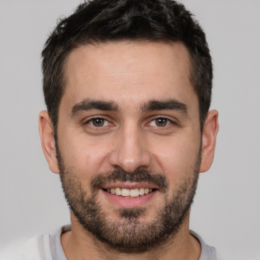 Joyful white young-adult male with short  black hair and brown eyes