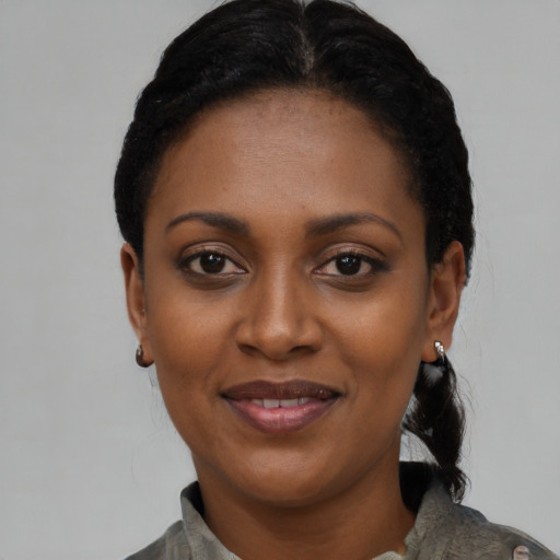 Joyful black young-adult female with short  black hair and brown eyes