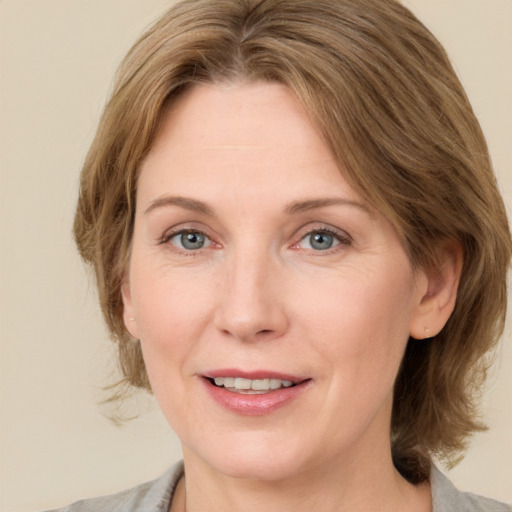 Joyful white adult female with medium  brown hair and green eyes