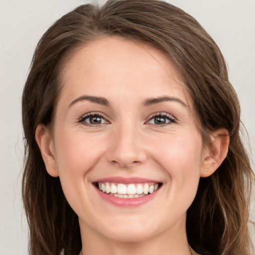 Joyful white young-adult female with long  brown hair and grey eyes