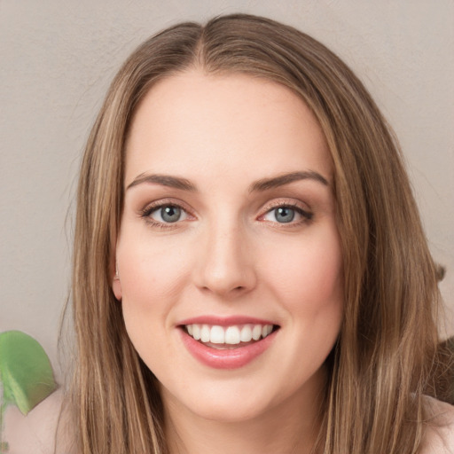 Joyful white young-adult female with long  brown hair and green eyes