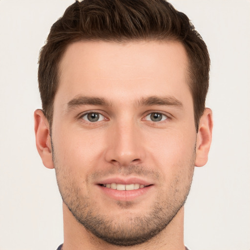 Joyful white young-adult male with short  brown hair and grey eyes