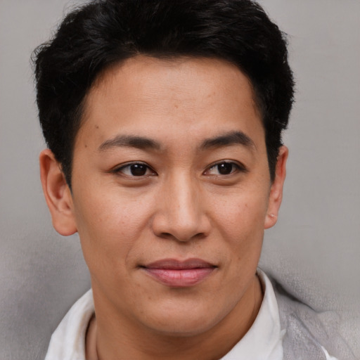 Joyful asian young-adult male with short  brown hair and brown eyes