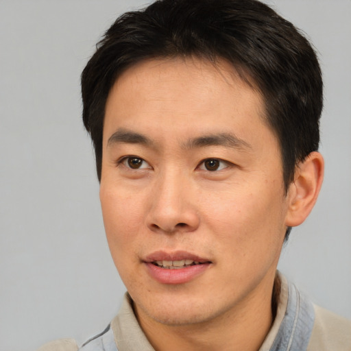 Joyful asian young-adult male with short  brown hair and brown eyes