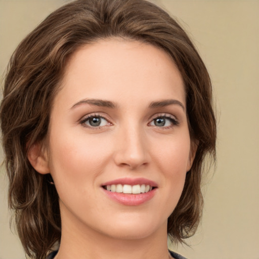 Joyful white young-adult female with medium  brown hair and green eyes