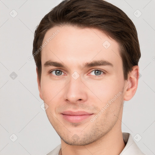 Joyful white young-adult male with short  brown hair and grey eyes