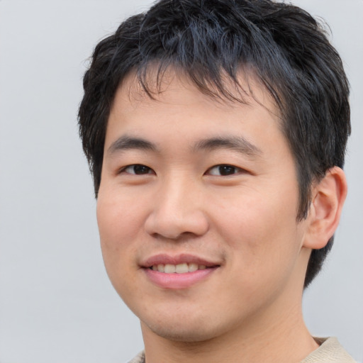 Joyful asian young-adult male with short  brown hair and brown eyes