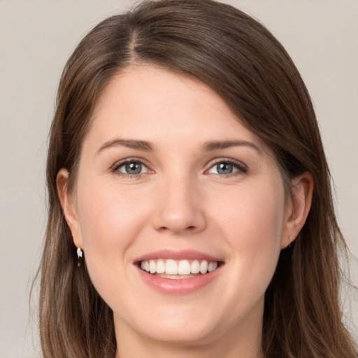 Joyful white young-adult female with long  brown hair and grey eyes