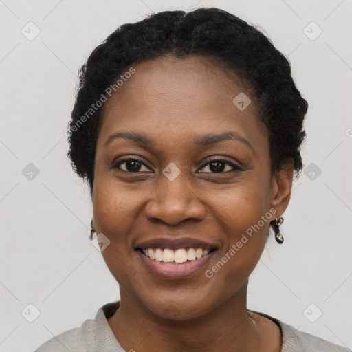 Joyful black young-adult female with short  black hair and brown eyes