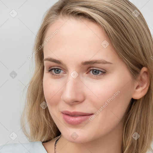 Joyful white young-adult female with long  brown hair and blue eyes