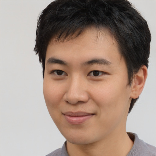 Joyful asian young-adult male with short  brown hair and brown eyes