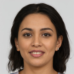 Joyful latino young-adult female with medium  brown hair and brown eyes