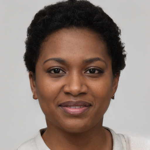 Joyful black young-adult female with short  black hair and brown eyes