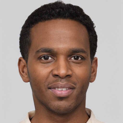 Joyful black young-adult male with short  black hair and brown eyes