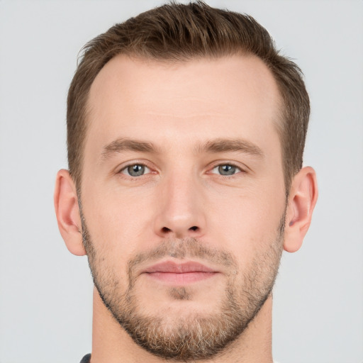 Joyful white young-adult male with short  brown hair and grey eyes