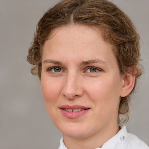 Joyful white young-adult female with medium  brown hair and blue eyes