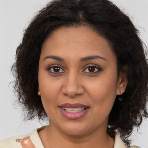 Joyful latino adult female with medium  brown hair and brown eyes