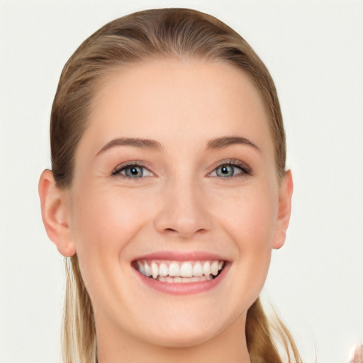 Joyful white young-adult female with long  brown hair and blue eyes