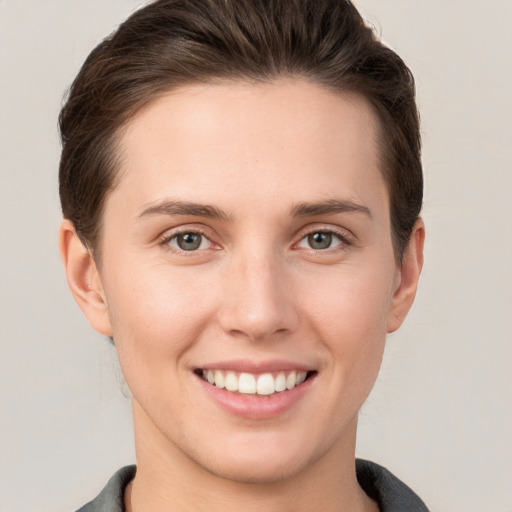 Joyful white young-adult female with short  brown hair and grey eyes