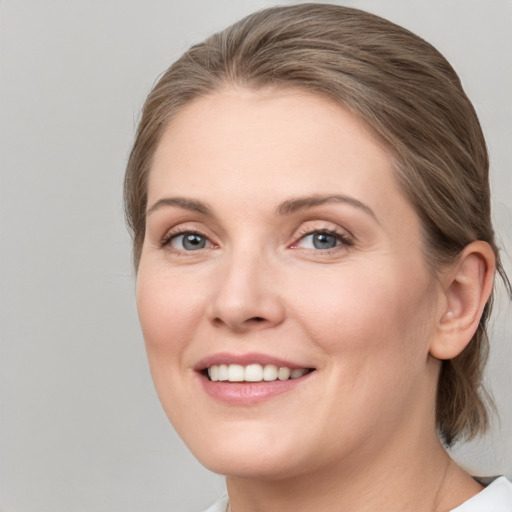 Joyful white young-adult female with medium  brown hair and blue eyes