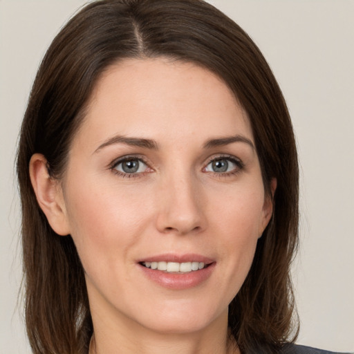 Joyful white young-adult female with medium  brown hair and grey eyes