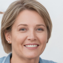 Joyful white adult female with medium  brown hair and blue eyes