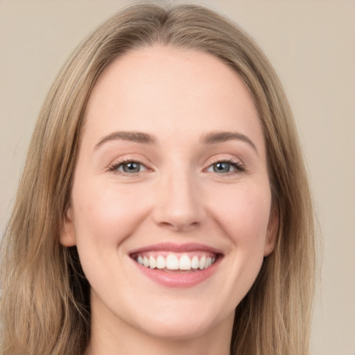 Joyful white young-adult female with long  brown hair and green eyes